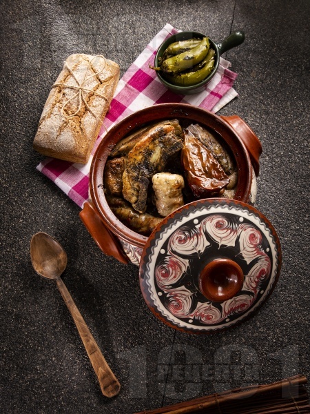 Разложка капама със сарми от кисело зеле, пълнени чушки, свинско месо и наденица в гювеч или глинено гърне - снимка на рецептата